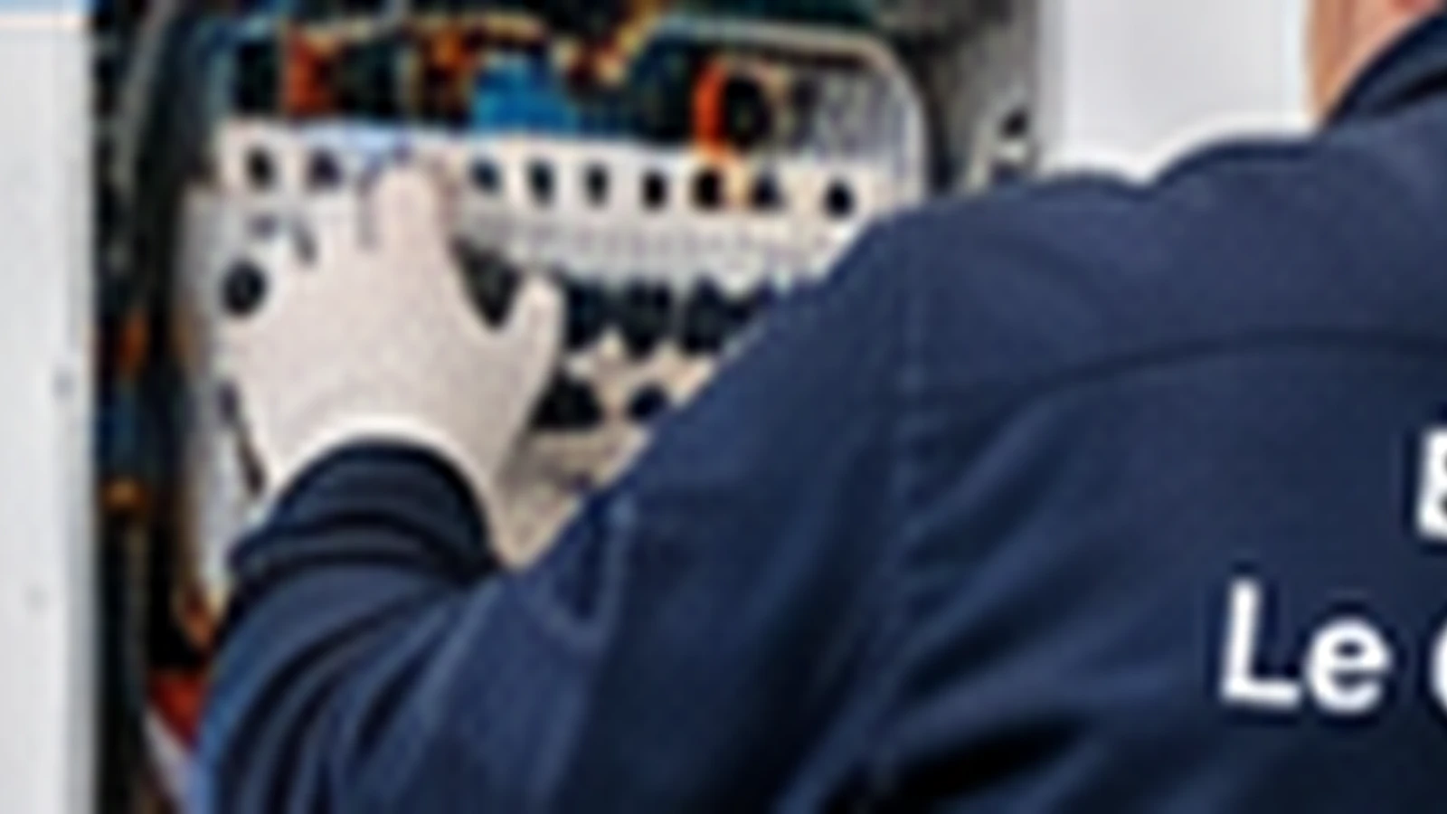 Électricien contrôlant un tableau électrique pendant une recherche de panne